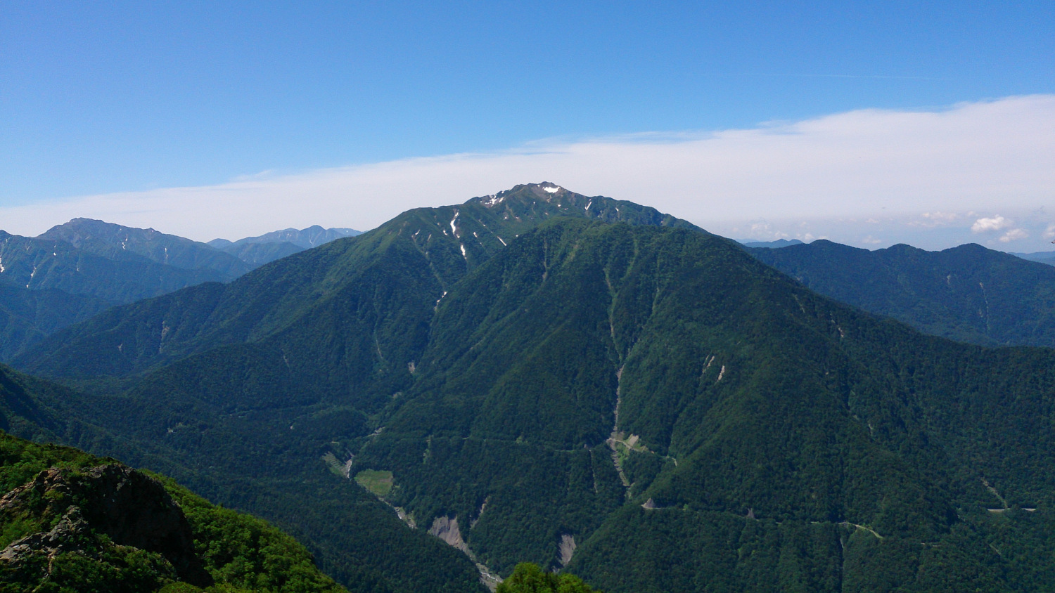 鋸岳第一高点から見る仙丈ケ岳、麓を横切る南アルプス林道も見える